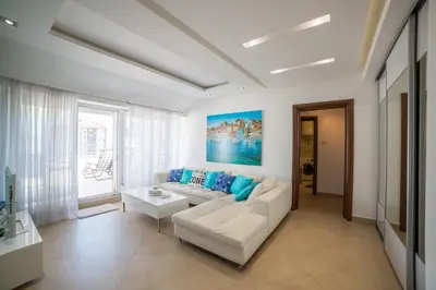 a living room with a white couch and blue pillows at Apartman Natalia in Budva