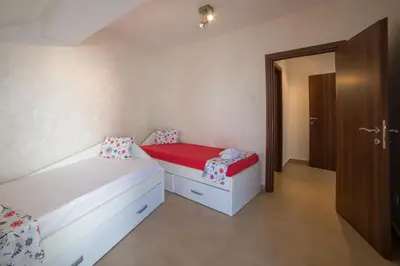 a small bedroom with two beds and a door at Apartman Natalia in Budva