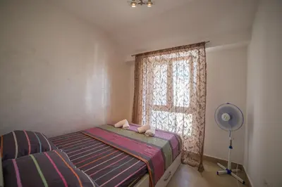 a bedroom with a bed and a window with a fan at Apartman Natalia in Budva
