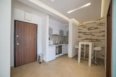a kitchen with a wooden door and a table at Apartman Natalia in Budva