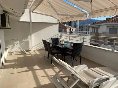 a patio with a table and chairs on a balcony at Apartman Natalia in Budva
