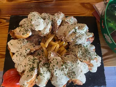 a plate of food with french fries on a table at Ethno village Moraca - Skadar lake in Vranjina