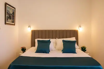 a bedroom with a bed with blue and white pillows at Apartments Vojislav in Virpazar
