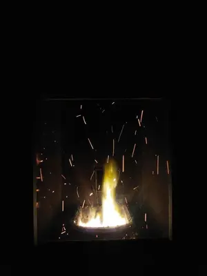 a fire in a fireplace at night with sparks at Holiday Home Milanovic in Cetinje