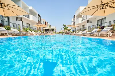 a swimming pool at a hotel with chairs and umbrellas at Hotel Halibas in Ulcinj