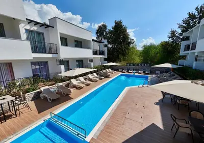 a swimming pool with chairs and umbrellas next to a building at Hotel Halibas in Ulcinj