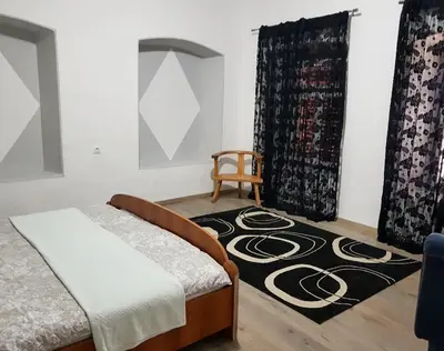 a bedroom with a bed and a chair and a rug at Harmony cozy home in Podgorica
