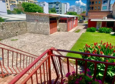 a balcony with a red railing and some flowers at Harmony cozy home in Podgorica
