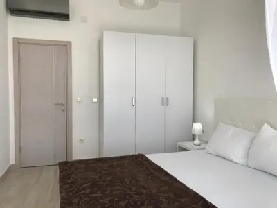 a bedroom with a large white bed and a closet at First line of the sea 1 in Dobra Voda