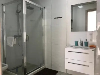 a bathroom with a glass shower and a sink at First line of the sea 1 in Dobra Voda