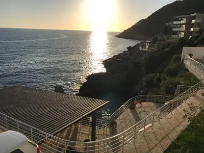 a view of the ocean with the sun setting on the beach at First line of the sea 1 in Dobra Voda