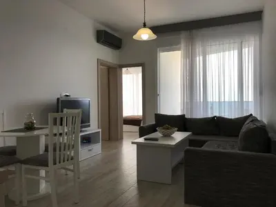 a living room with a couch and a tv at First line of the sea 1 in Dobra Voda