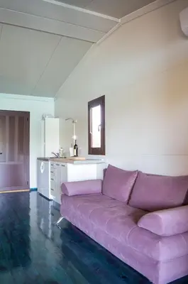 a purple couch in a room with a kitchen at Baraka in Ulcinj