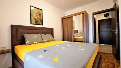 a bedroom with a large bed with a yellow blanket at Aleksa Lux apartment Budva in Budva