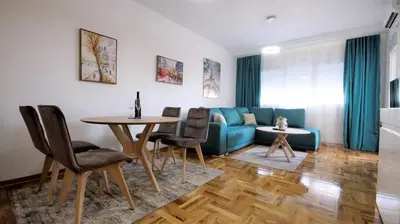 a living room with a blue couch and a table at Aleksa Lux apartment Budva in Budva