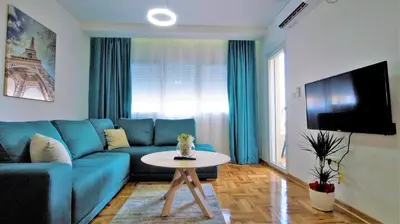 a living room with a blue couch and a table at Aleksa Lux apartment Budva in Budva