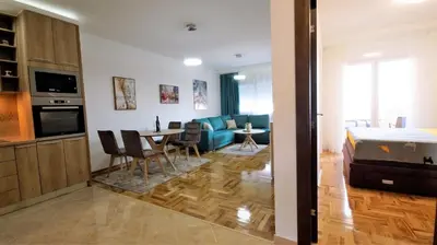a living room with a bed and a dining room at Aleksa Lux apartment Budva in Budva