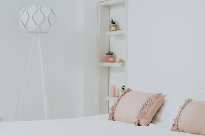 a white bedroom with two pillows on a bed at Apartments Trifunovic Old Town in Budva