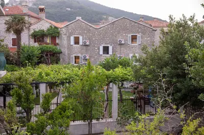 a house with a garden in front of it at Apartments Trifunovic Old Town in Budva