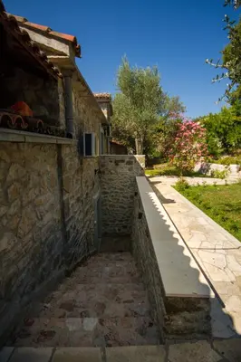 a stone building with a bench next to a sidewalk at Seaside Story in Tivat