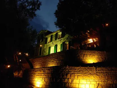a house with green lights on a brick wall at night at Seaside Story in Tivat