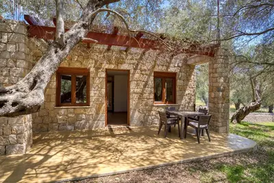 a stone house with a table and chairs outside at Stonehouse in Olives in Ulcinj