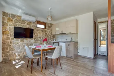 a kitchen and dining room with a table and chairs at Stonehouse in Olives in Ulcinj