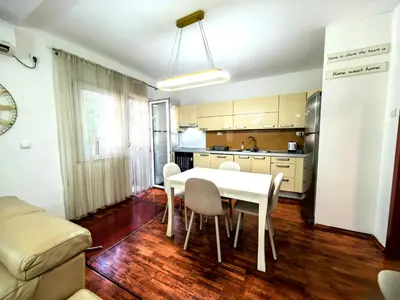 a kitchen and dining room with a white table and chairs at Luxury apartment Podgorica in Podgorica