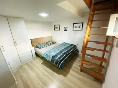 a small bedroom with a bed and a staircase at Luxury apartment Podgorica in Podgorica