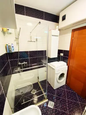 a bathroom with a toilet and a washing machine at Luxury apartment Podgorica in Podgorica