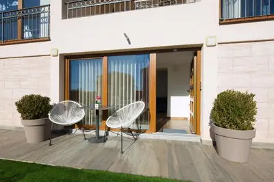 a patio with three chairs and a glass table at Villa Lazy Hill in Budva