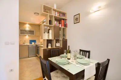 a kitchen and dining room with a table and chairs at LORDOR Apartment in Budva