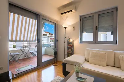 a living room with a couch and a balcony at LORDOR Apartment in Budva