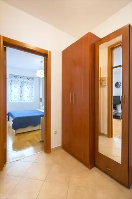 a room with a bedroom with a bed and a mirror at LORDOR Apartment in Budva