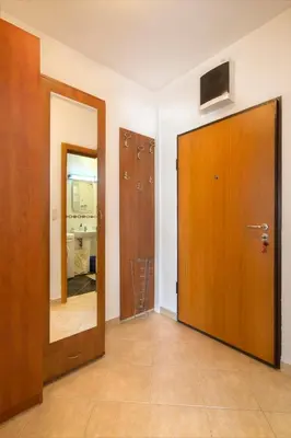 a hallway with a wooden door and a mirror at LORDOR Apartment in Budva