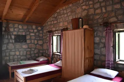 a room with two beds and two windows at Rent House Orahovo in Virpazar