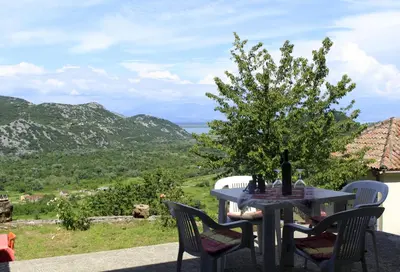 a table and chairs with a view of the mountains at Rent House Orahovo in Virpazar