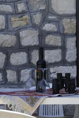a bottle of wine and two glasses on a shelf at Rent House Orahovo in Virpazar