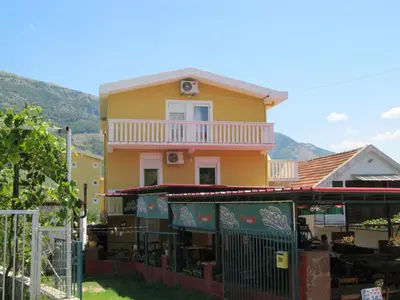 a yellow house with a fence in front of it at Vila AKI-KA in Sutomore