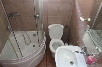 a bathroom with a toilet and a tub and a sink at Vila AKI-KA in Sutomore