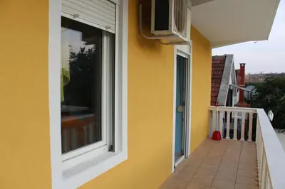 a yellow house with a window and a balcony at Vila AKI-KA in Sutomore