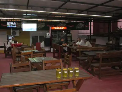 a restaurant with wooden tables and people sitting at tables at Vila AKI-KA in Sutomore