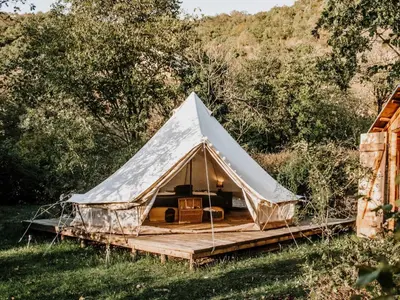 a canvas tent with a wooden platform in a field at Hoopoe Glamping in Virpazar