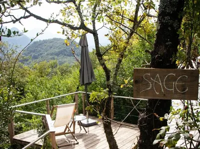 an umbrella and two chairs on a wooden deck at Hoopoe Glamping in Virpazar
