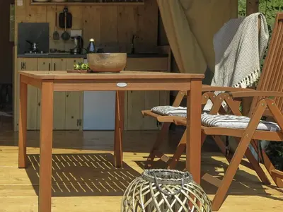 a wooden table with a bowl on it next to a chair at Hoopoe Glamping in Virpazar