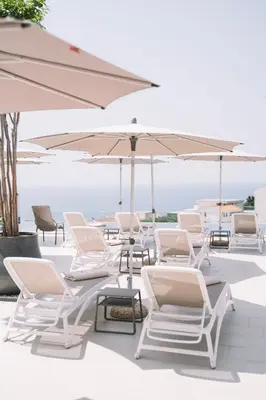 a group of chairs and umbrellas on a patio at Padam Hotel & SPA in Ulcinj