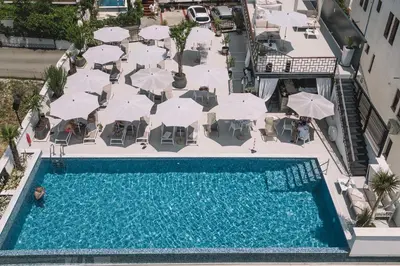 an overhead view of a swimming pool with tables and umbrellas at Padam Hotel & SPA in Ulcinj