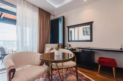 a living room with a table and chairs and a mirror at Padam Hotel & SPA in Ulcinj