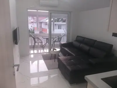 a living room with a couch and a table with chairs at Studio 033 in Budva