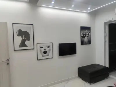 a white wall with pictures and a black stool at Studio 033 in Budva